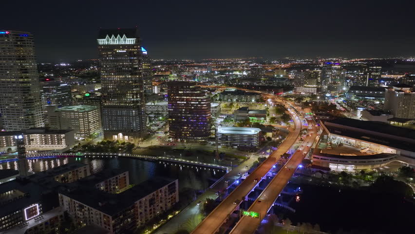 Aerial view of downtown district of Tampa city in Florida, USA. Brightly illuminated high skyscraper buildings and moving traffic in modern american midtown