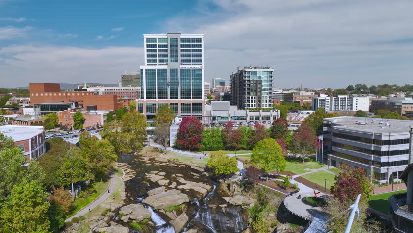 Aerial view of Reedy River Waterfalls in downtown of Greenville city in South Carolina. Falls Park riverwalk at Liberty bridge. American travel destination.
