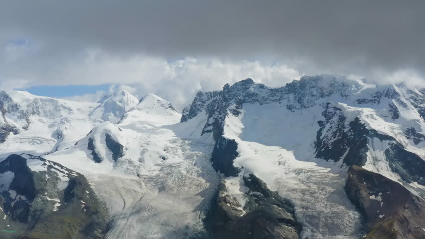 Switzerland. Aerial view of Monte Rosa massif, flanked by glaciers, is the highest mountain in the Swiss Alps. It has ten 4000m peaks. The Dufourspitze on the Monte Rosa massif is the highest peak Royalty-Free Stock Footage #1103015355