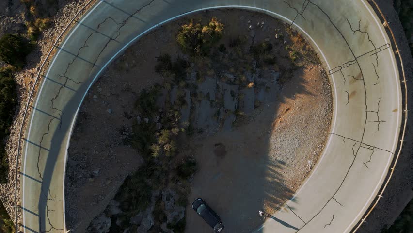 Modern cars at Hairpin Bend at Sa Calobra, Palma de Mallorca. Serpentine road in the mountains. Scenic epic Majorca Island nature aerial drone footage. Famous for racing bicycles. Cinematic 4K UHD