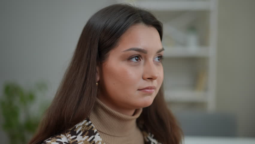 Close-up portrait of charming Caucasian young woman looking around sitting indoors. Headshot of attractive brunette lady with brown eyes waiting | Shutterstock HD Video #1103022187