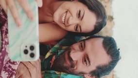 VERTICAL VIDEO: Close up, young couple talking and laughing while watching video on mobile phone