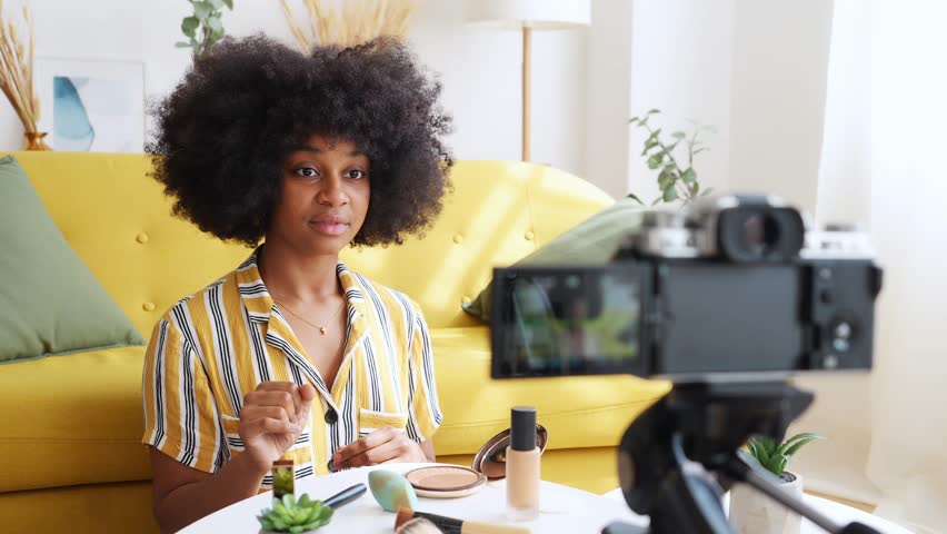 Cheerful black woman recording video on camera. skin care