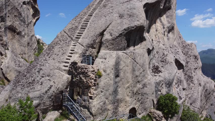 AERIAL: Norman stairs in Castelmezzano, Italy, a small village dug into the rock in the natural park of the Dolomiti Lucane, Basilicata region - famous also for the spectacular "Angel flight".  Royalty-Free Stock Footage #1103025117