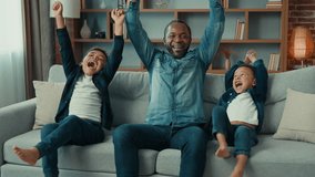 Excited African American happy family father and two siblings boys kids children fans watch TV sport game championship celebrate goal television team victory in sport match sit on sofa cheer together - Powered by Shutterstock - Get 15% off with code: PIKWIZARD15