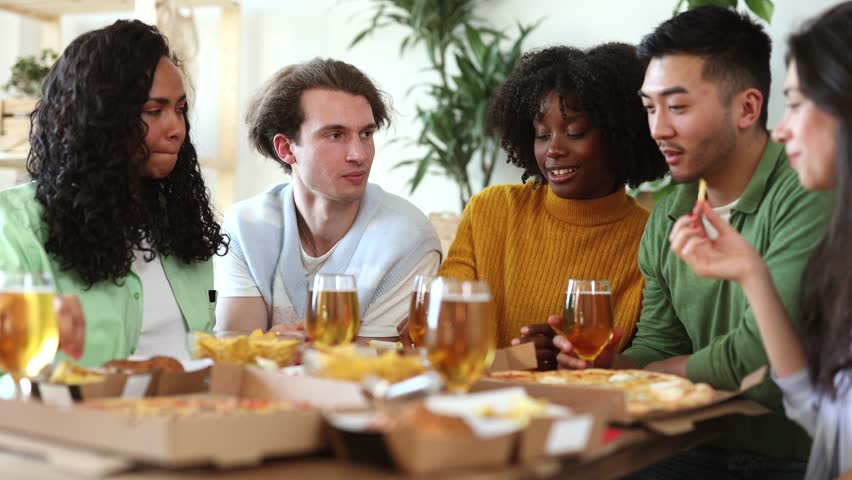 Happy multiracial friends eating pizza together at home - happy friends meal , food delivery young people having dinner indoors. Royalty-Free Stock Footage #1103026423