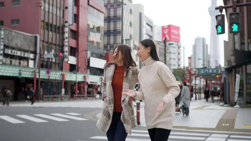 Asian woman friends crossing street crosswalk with crowd of people during travel together Asakusa district, Tokyo, Japan. Attractive girl enjoy urban outdoor lifestyle travel city on holiday vacation. Royalty-Free Stock Footage #1103032361