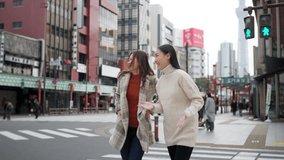 Happy woman travel walking, shopping in the city on holiday vacation. Asian women friends enjoy and fun outdoor lifestyle crossing city street crosswalk with crowd of people at Asakusa, Tokyo, Japan. - Powered by Shutterstock - Get 15% off with code: PIKWIZARD15