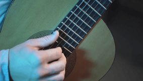 a man plays the acoustic guitar in a professional studio. Blogging, musical instruments and lifestyle concept. close-up.slow-motion video.. High-quality FullHD video recording