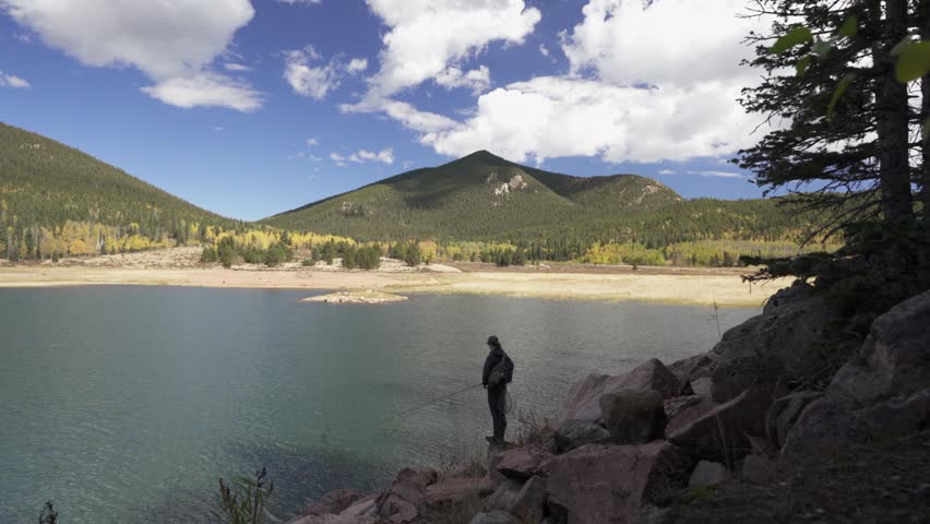 Young man fishes in low water Penrose Rosemont Reservoir, Colorado