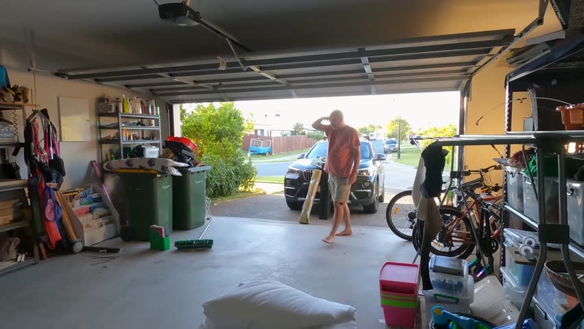 A mature couple is tidying up cluttered a double garage. Royalty-Free Stock Footage #1103038307