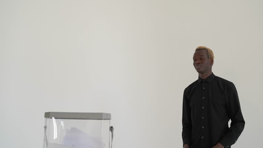 african american drops the ballot into the political election box