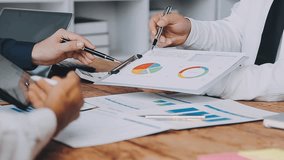 Financial analysts analyze business financial reports on a digital tablet planning investment project during a discussion at a meeting of corporate showing the results of their successful teamwork. - Powered by Shutterstock - Get 15% off with code: PIKWIZARD15
