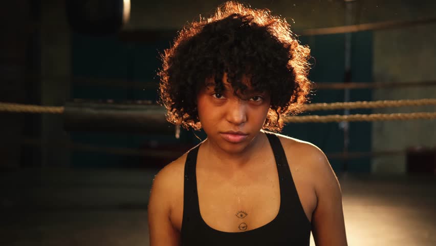 Outcry independent girl power. Angry african american woman fighter with boxing gloves looking serious aggressive to camera standing on boxing ring. Strong powerful girl looking concentrated straight Royalty-Free Stock Footage #1103048217