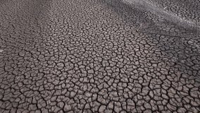 Land with dry and cracked ground, Sau swamp in Catalonia, Spain. Aerial forward tilt-up reveal drone low. Global warming and environmental disaster concept