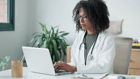Video of confident female doctor using her mobile phone while working on laptop in the consultation. - Powered by Shutterstock - Get 15% off with code: PIKWIZARD15