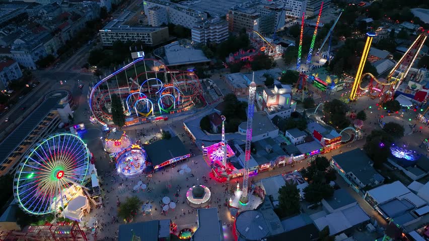 Aerial view fun fair. Twilight time illumination Vienna city famous theme amusement park Prater riverside downtown aerial panorama 4k Austria Royalty-Free Stock Footage #1103053867