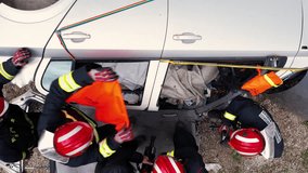 Aerial view Car Crash Traffic Accident. Firefighters Rescue Injured Trapped Victims. Firemen give First Aid to passengers on Stretchers. High quality 4k footage