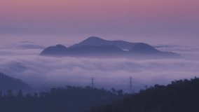 4K time-lapse video motion. Aerial view high voltage power transmission towers or electricity pylon in fog on mountain mae moh lampang.