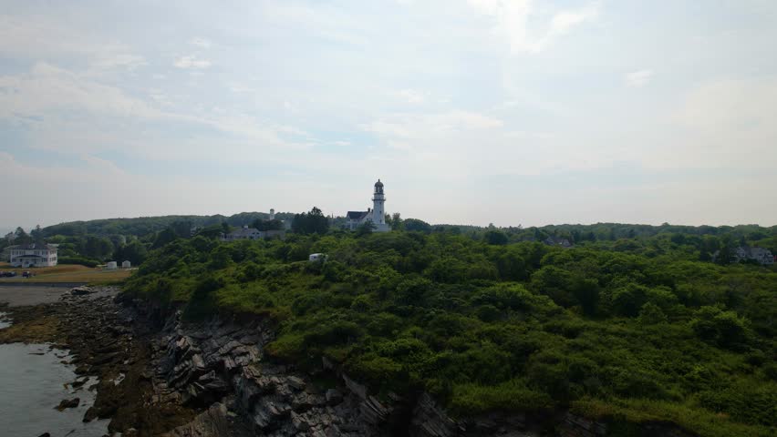 Cape Elizabeth twin lighthouses establishing video with backwards tracking. Scenic coastline of southern Maine with coastal shrubbery and rocky bluffs on a warm summer day at Dyer Cove.