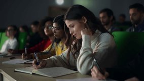 Talented Smart Female Student Studying in College with Diverse Multicultural Colleagues. She is Writing Down a Summary from the Lecture in Her Notebook - Powered by Shutterstock - Get 15% off with code: PIKWIZARD15