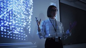 Young Businesswoman Giving a Data Science Presentation in a Dark Auditorium with Projecting Slideshow with Artificial Intelligence Neural Network Architecture. Business Startup and Education Concept - Powered by Shutterstock - Get 15% off with code: PIKWIZARD15
