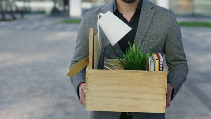 Close Up Hands of Jobless Caucasian Business Man Carrying a Box Containing Work Items. Male Manager Walking Near the Business Centre. Fired Work People Concept Royalty-Free Stock Footage #1103075409