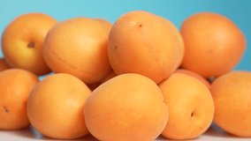 Close up view 4k stock video footage of female hand taking fresh riped juicy big apricots one by one