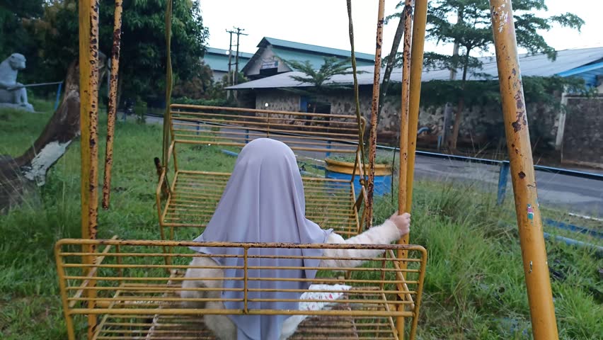 West Java, Indonesia - 26th April 2023: A Young Girl Playing The Old Swing