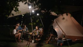 Group of Asian man and woman friends enjoy outdoor lifestyle celebrating holiday party having dinner with playing guitar and singing together during travel nature camping in forest on summer vacation. - Powered by Shutterstock - Get 15% off with code: PIKWIZARD15