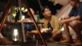 4K Group of Happy Asian people having dinner and talking together during camping in forest at night. Man and woman friends enjoy outdoor adventure lifestyle travel nature on summer holiday vacation. - Powered by Shutterstock - Get 15% off with code: PIKWIZARD15