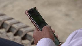 boy holding mobile phone in hand and someone is doing work using it slow motion close up shot stock video 