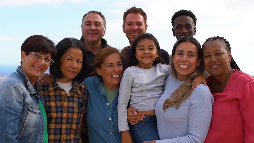 Group of multigenerational people hugging each other while smiling on camera - Multiracial friends having fun together outdoor Royalty-Free Stock Footage #1103093727