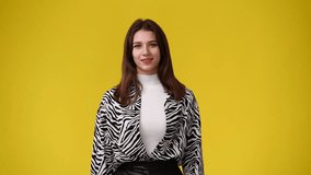 4k video of cute girl showing OK sign on yellow background.