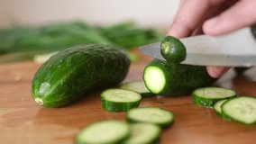green cucumbers are cut with a knife in the kitchen. healthy food salad vegetables concept. close-up green cucumbers in the kitchen hands close-up cut lifestyle into slices - Powered by Shutterstock - Get 15% off with code: PIKWIZARD15