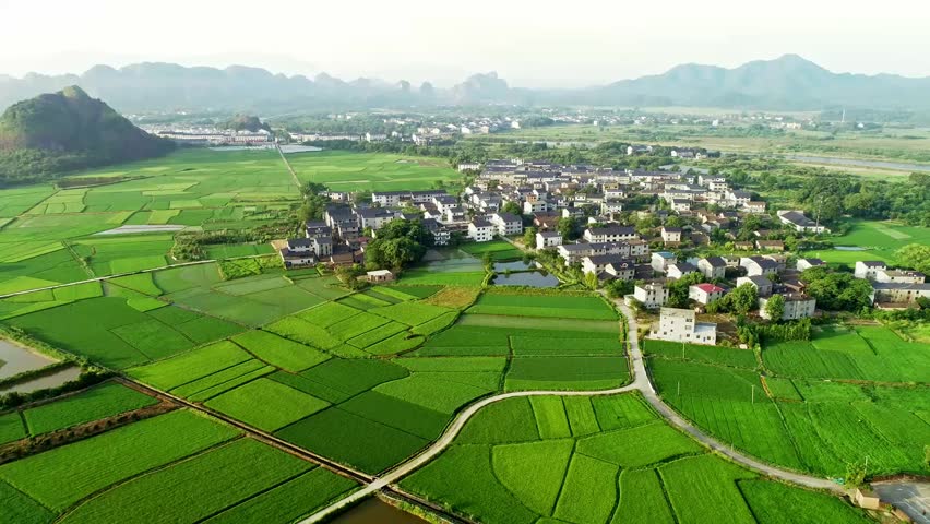 Camera moving forward, aerial view, green farmland and a beautiful mountain village in southern China | Shutterstock HD Video #1103104915