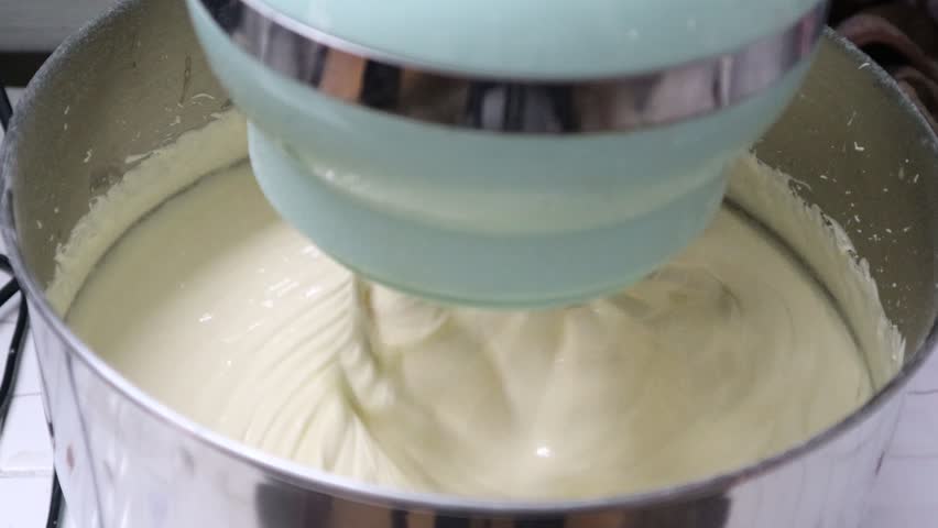 Closeup of Stand Mixer Beaters in Above Vanilla Cake Batter, Cake batter that has been mixed in an electric stand mixer bowl. Royalty-Free Stock Footage #1103105727