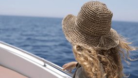 a video of a women on a boat with hair flying on the wind and beautiful blue water, a perfect sailing vacation around the island enjoying summer