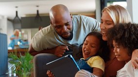 Family at home pulling funny faces using digital tablet to take selfie with grandparents in background - shot in slow motion - Powered by Shutterstock - Get 15% off with code: PIKWIZARD15