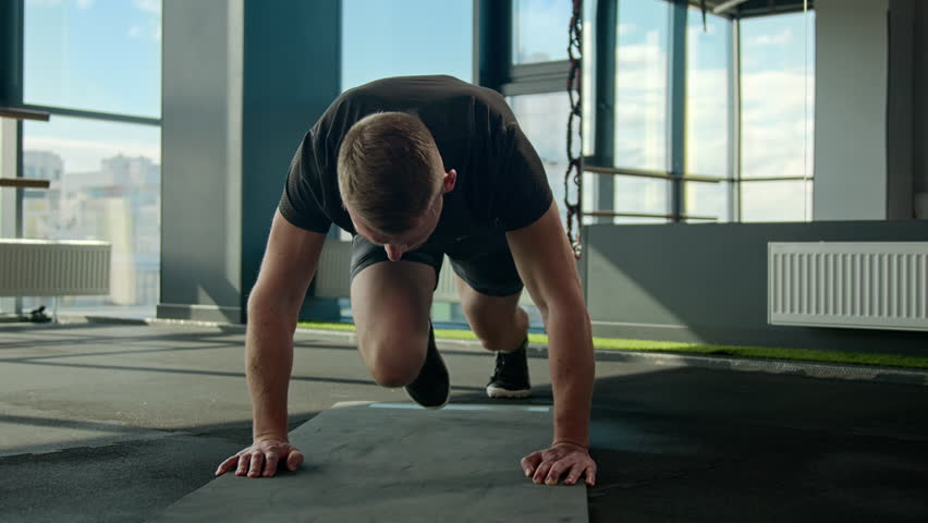 Caucasian sportsman sport trainer doing mountain climber exercise running plank on fitness mat male athlete runner bending knees strong man training endurance healthy lifestyle cardio workout in gym Royalty-Free Stock Footage #1103117337