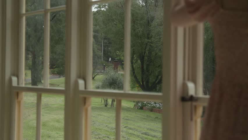 Watch as a young blonde girl frantically bangs on a window during a summer