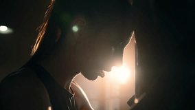 Silhouette face of young tired exhausted sportswoman boxer loaning head to punching bag, side view. Sweaty girl is resting after workout. Training box, practicing fight, professional sport concept. - Powered by Shutterstock - Get 15% off with code: PIKWIZARD15