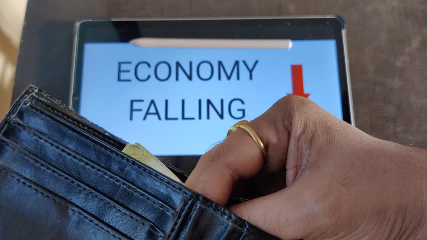 Footage of a person taking out money from his wallet. ECONOMY FALLING with a downward pointing arrow is written in background. Footage is depicting economic fall. Royalty-Free Stock Footage #1103118653