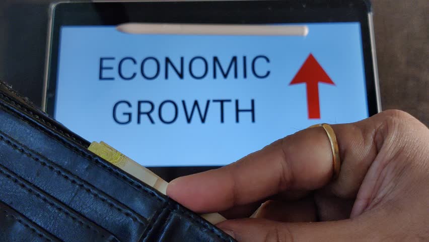 Footage of a person taking out money from his wallet. ECONOMIC GROWTH with an upward pointing arrow is written in background. Footage is depicting economic growth.
 Royalty-Free Stock Footage #1103118849