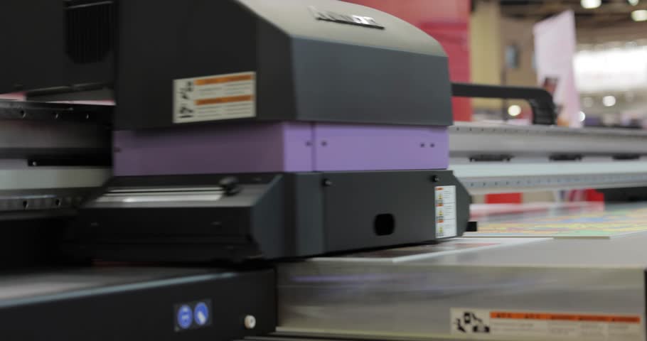 Modern Digital Large format UV printer. Printing production technologies. UV pinning is the process of applying a dose of low intensity ultraviolet light to a UV curable ink Royalty-Free Stock Footage #1103118907
