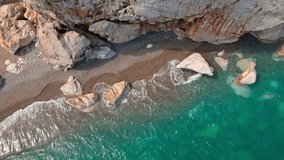 aerial drone video top down bird's eye view along shoreline of secret Beach and waves breaking on Turquoise Coast near Antalya, Kas, Turkey. 4k at 25fps