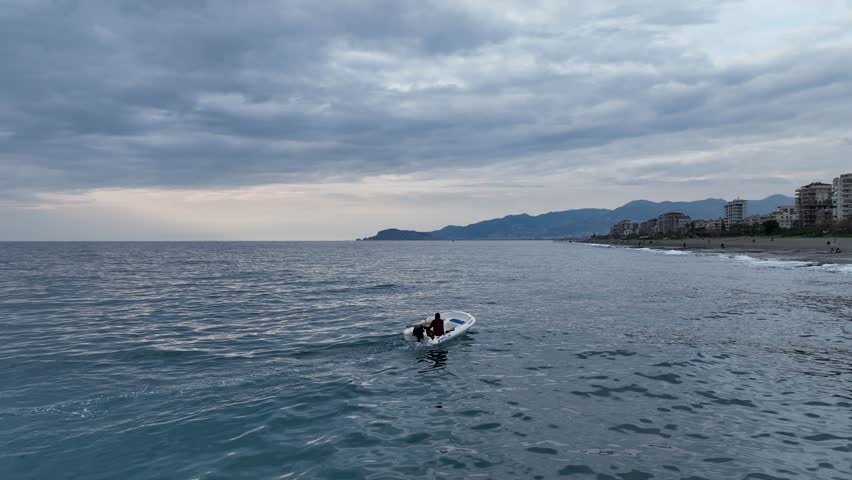 Old fisherman spreads his fishing nets in the sea, near the shore aerial view background fishing near the shore in his small boat 4K