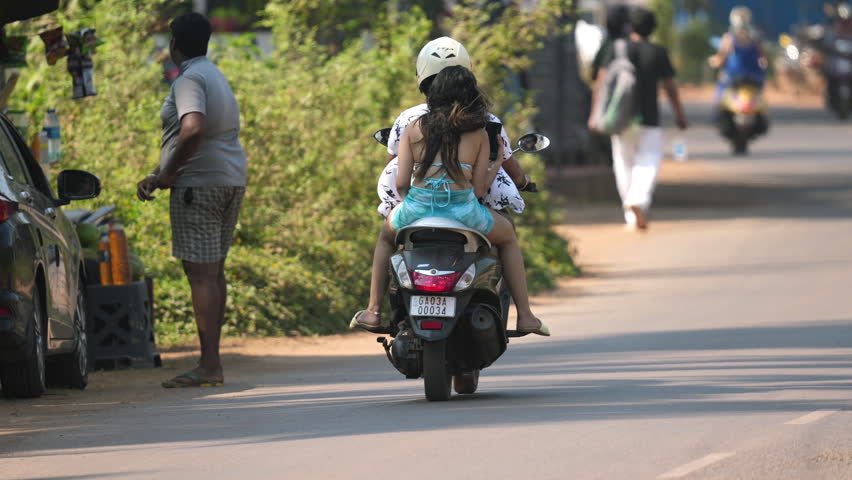 indian female biker ride moped. Motorcyclist drive moto bike. India road way trip. Lot rural two wheel motorcycle. Fast city traffic roadway jam. People went motor scooter travel. Woman move motorbike