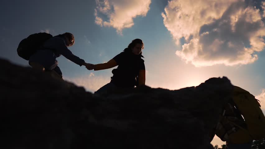 Helping hand in teamwork.Group of climbers daring climb to victory.People reach out to each other by hand providing help and support at every step of way.Power of teamwork.Together reach new heights Royalty-Free Stock Footage #1103134483
