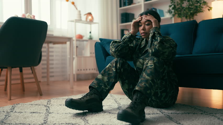 Military woman sitting on the floor, mental health problems, uncertain future
